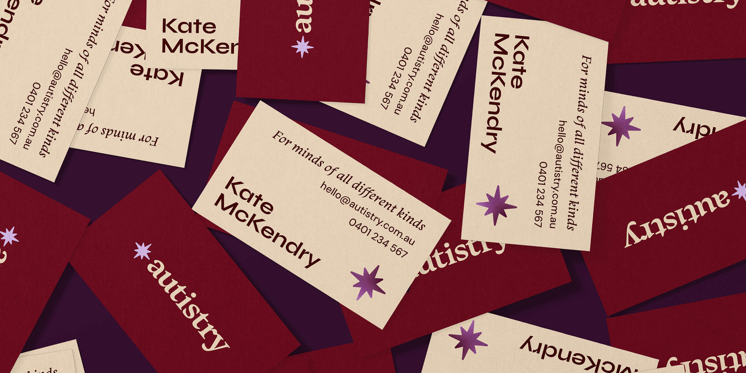 Unique retro psychologist branding design image shows the Autistry psychologist custom colourful business card designs on a dark purple background. The front of the vintage inspired business card design shows the logo in cream on a deep maroon background while the back has the psychologist business card details on cream.