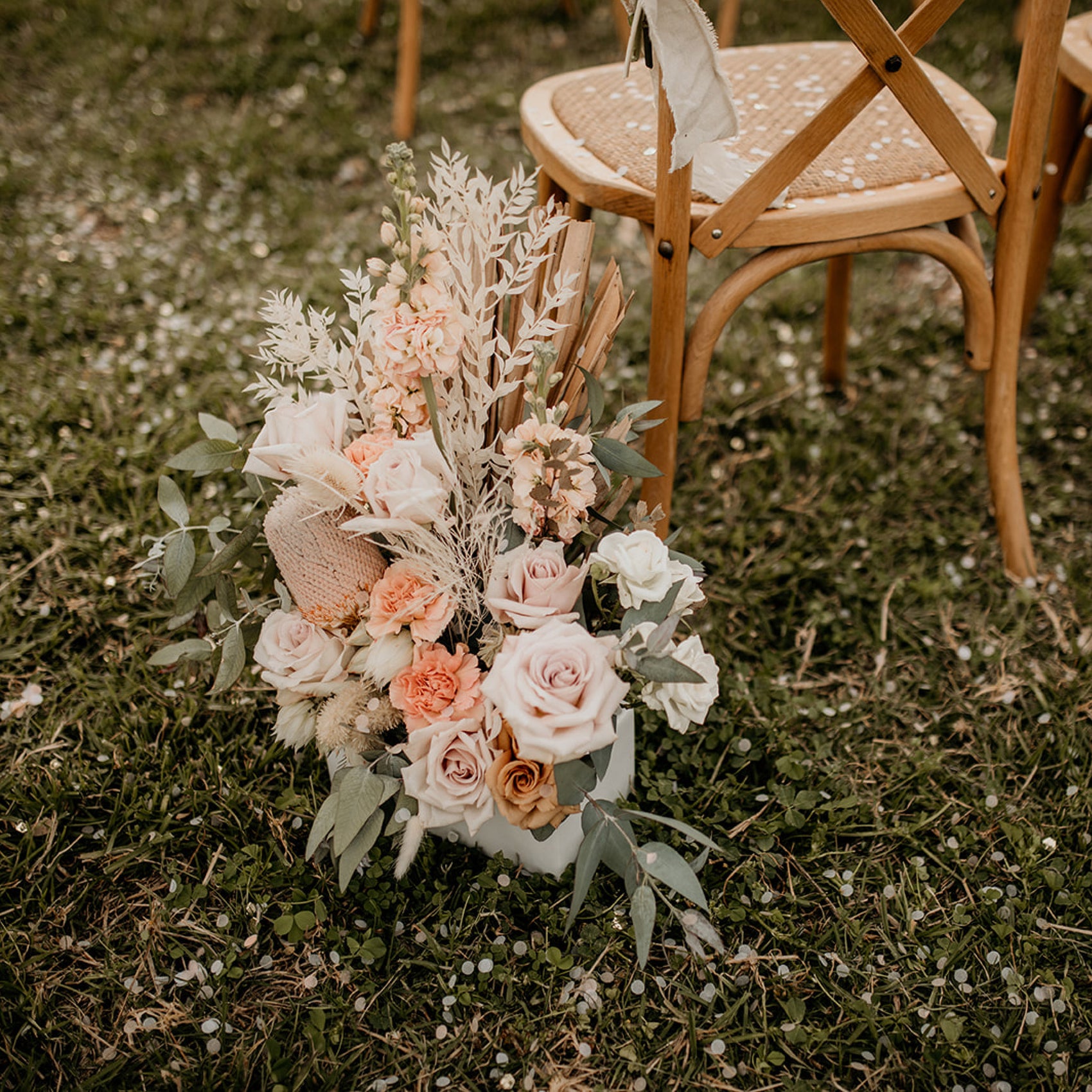 Rebranding case study image featuring brand photography for Eco Confetti. A chair at an event is covered with eco confetti, a bouquet and grass also visible.