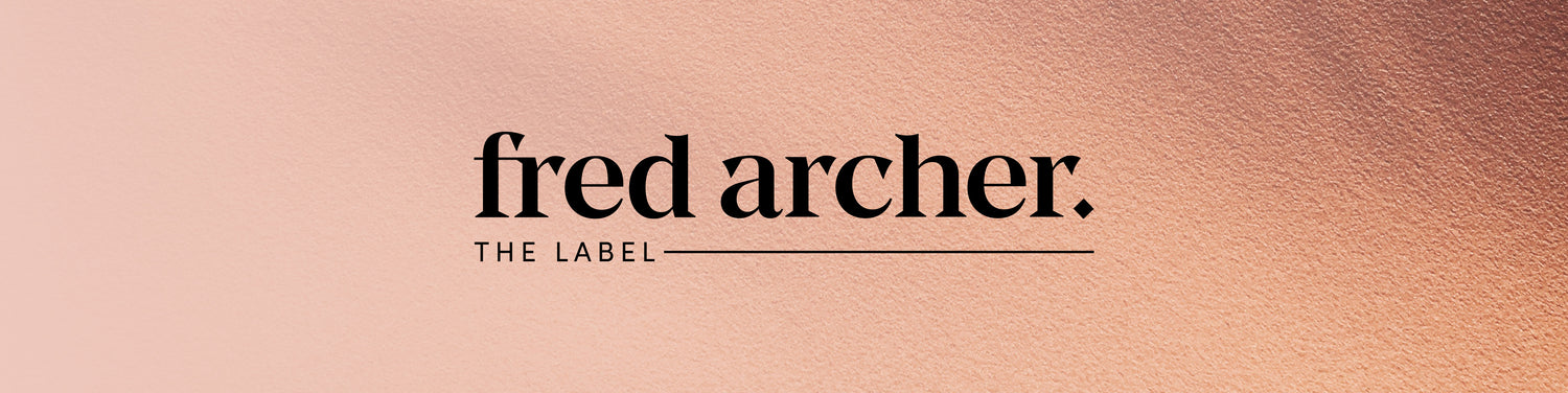 Fashion brand identity inspiration image of the Fred Archer logotype. Set in black on a pink sandy background, the minimal logo aesthetic makes for a clean, sophisticated logotype. 