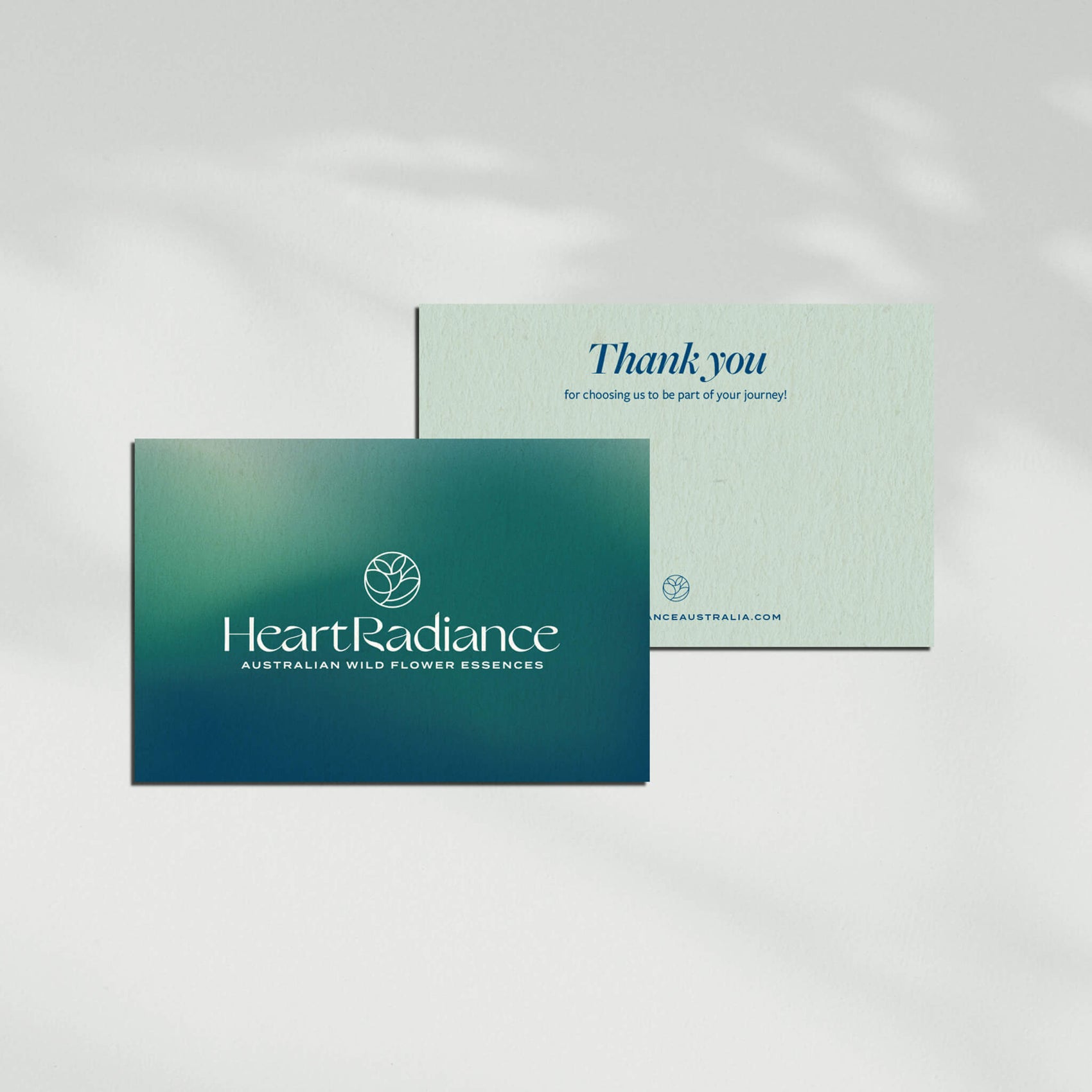 Brand design portfolio image of HeartRadiance’s thank you cards. The front image features the brand logo on a blue/ green gradient background while the back features room for a message.