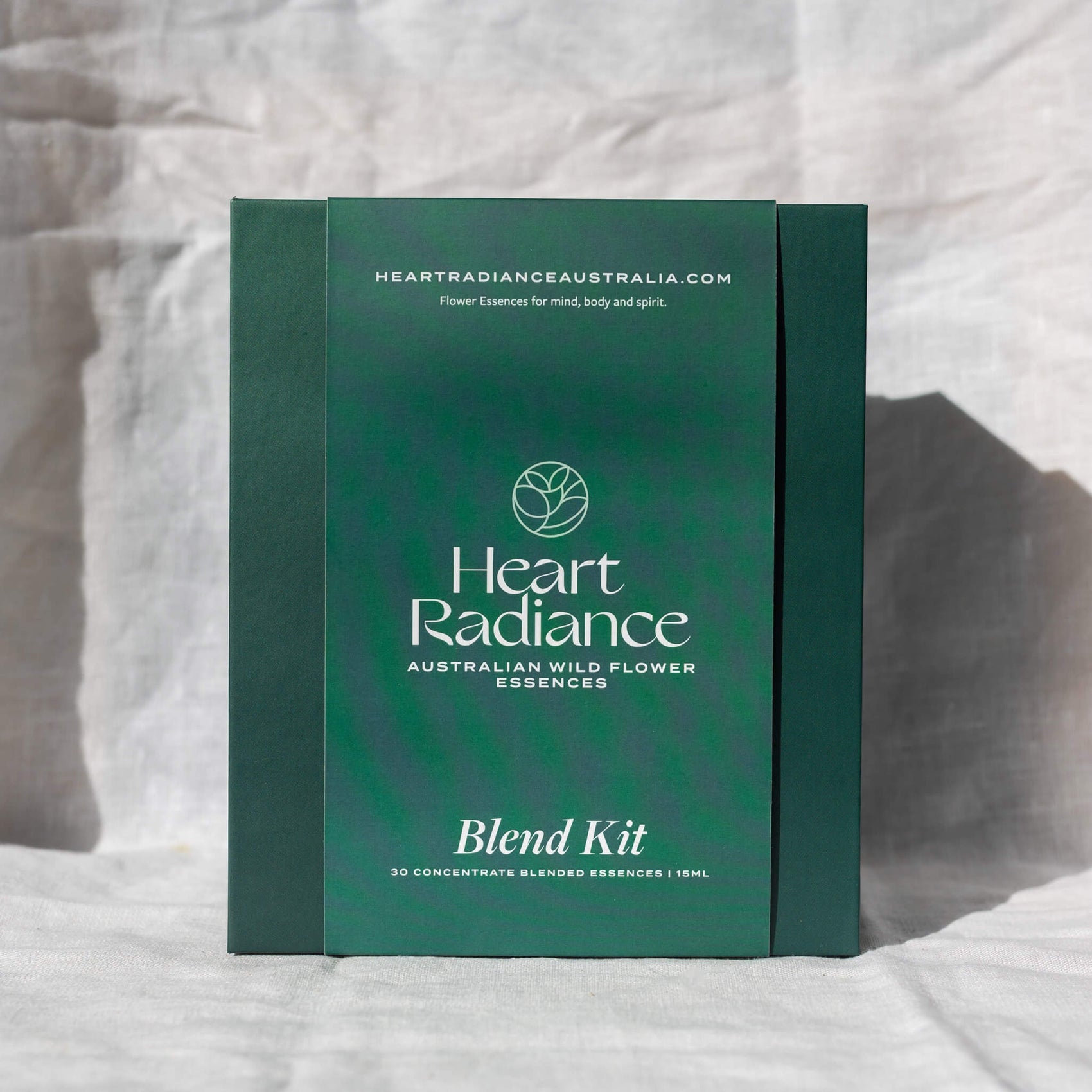 Brand identity case study image of the HeartRadiance kit box in front of a white background. The deep green box features a green belly band with elegant white typography. 
