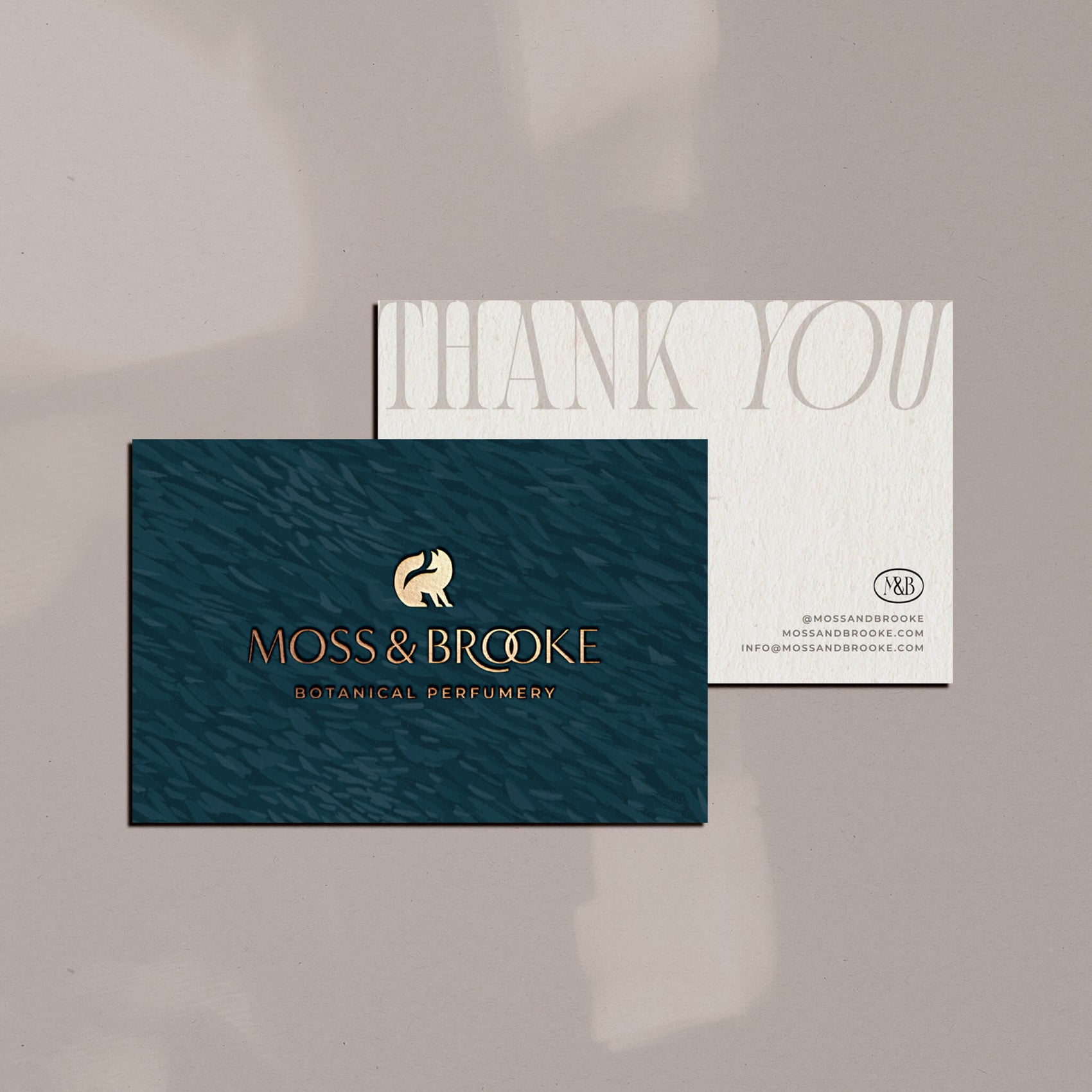 Soap rebranding case study image of the Moss & Brooke branded thank you cards. Featuring a linocut brand texture and gold foil detailing, the cards have blank backs for a handwritten message.