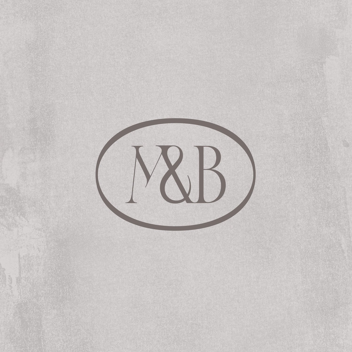 Perfume brand identity case study image of the Moss & Brooke brand seal on a cream coloured background. The logo shows an interconnected M&B in a minimal serif style, an oval surrounding them. 