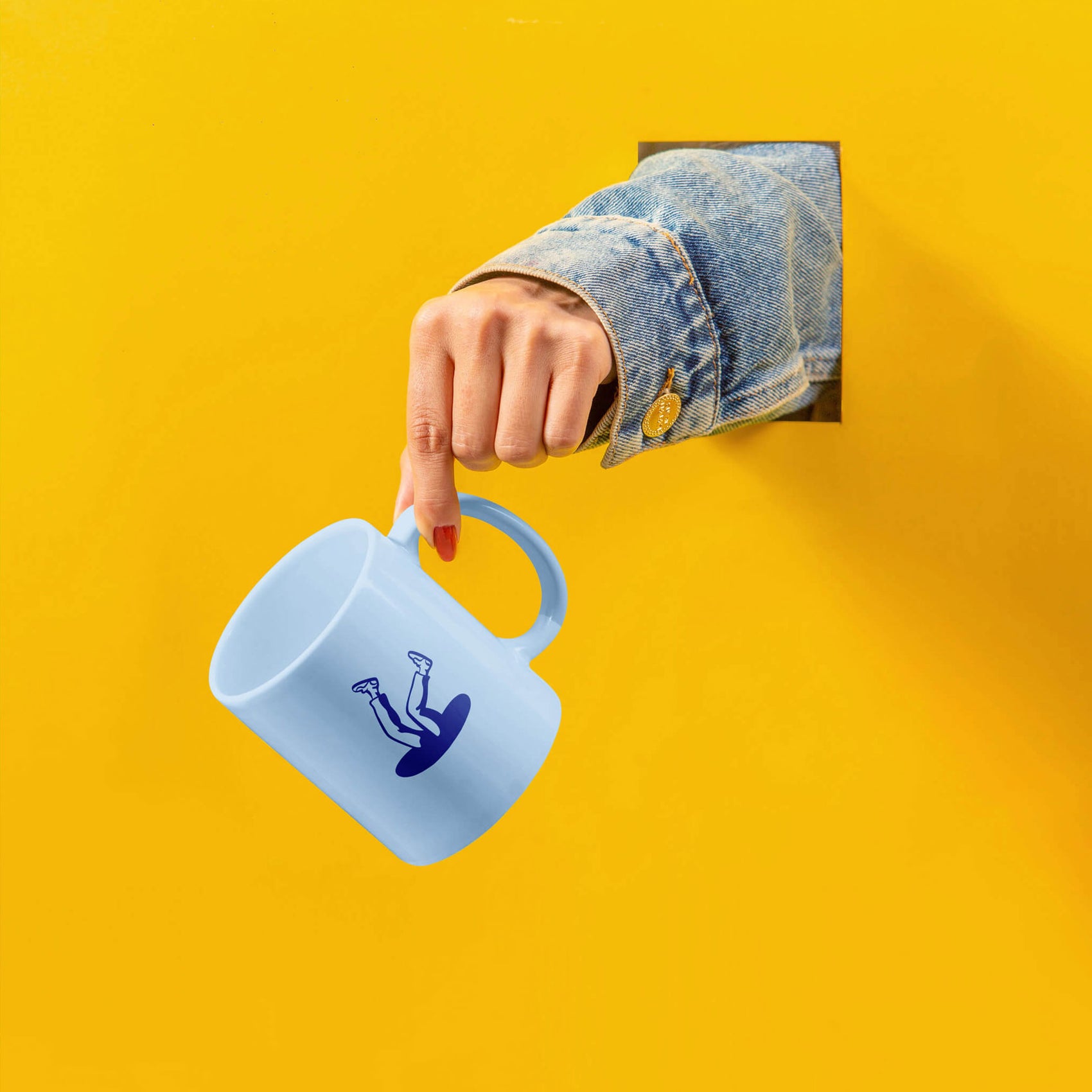 Brand designer portfolio image of a light blue Parallel mug emerging from a yellow background, an arm wearing a denim jacket emerging from a hole. 