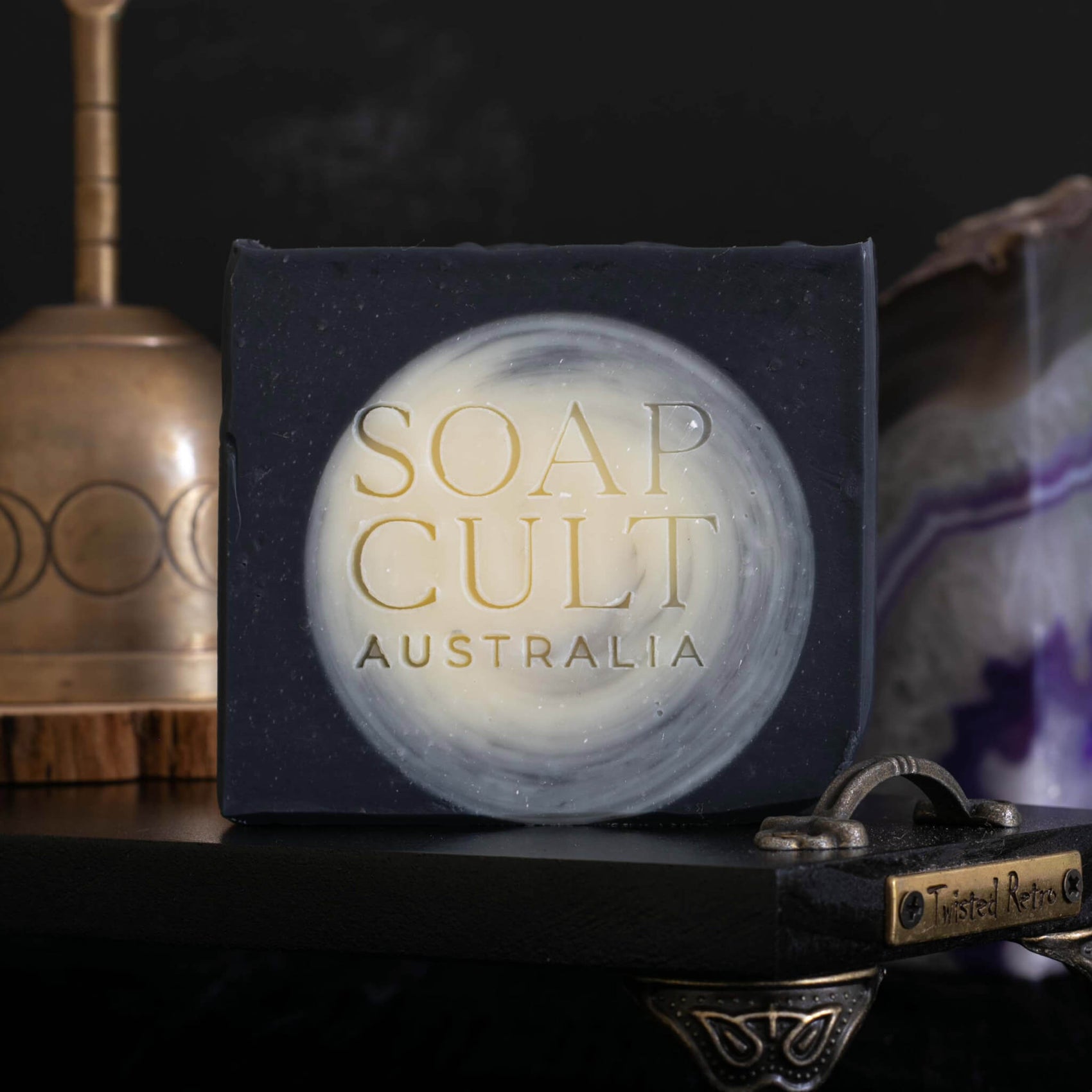 Brand designer portfolio image of a Soap Cult Australia soap. The black and white soap bar features a stamped custom logo, its elegant serifs a feature to the goth aesthetic branding.