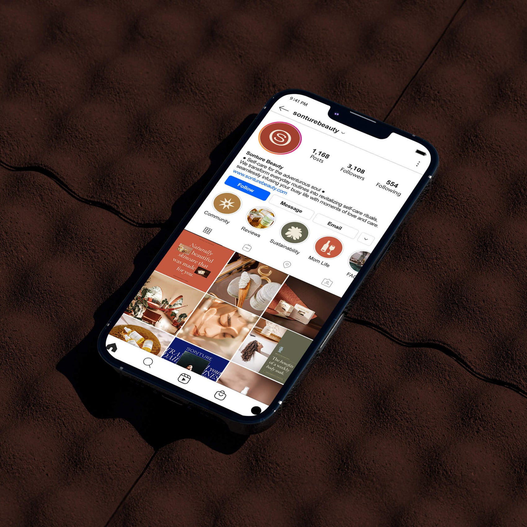 Brand designer portfolio image of the Sonture Instagram feed. The iphone sits on a brown tiled surface and screen displays the warm colours of the brand identity design.