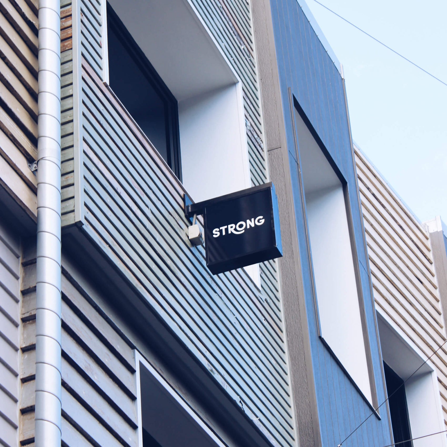 An image for the rebranding case study of Strong Digital shows the Strong Digital agency logo design on a lightbox on the site of an office building. 