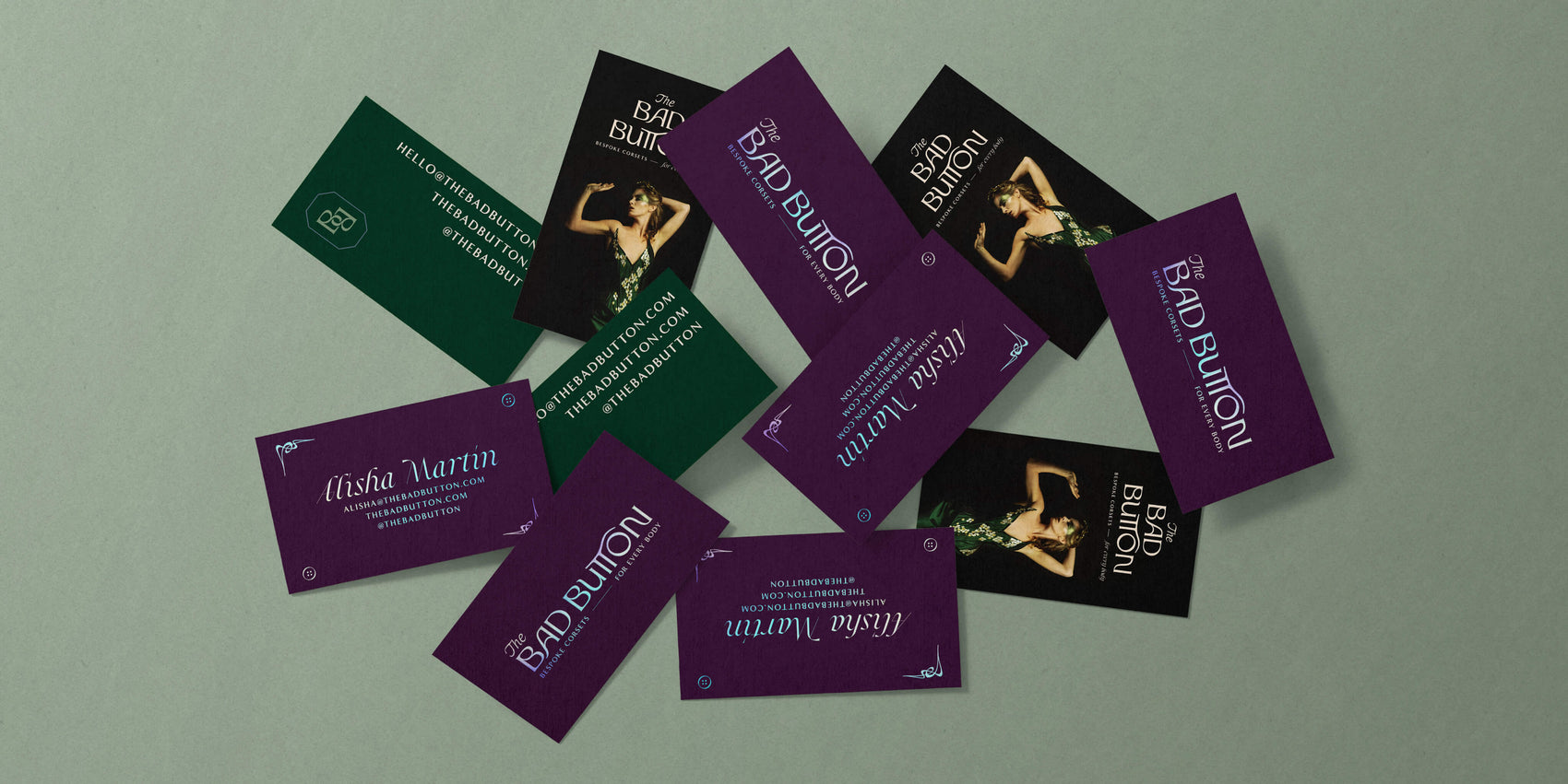 Brand Designer Portfolio image of The Bad Button’s business card varieties. One (for shows) features an image of a corset with the brand logo and a green back with contact details. The other (for more personal use) shows a purple cardstock and holographic foiling- the front with the brand logo and the back with founder Alisha’s details.
