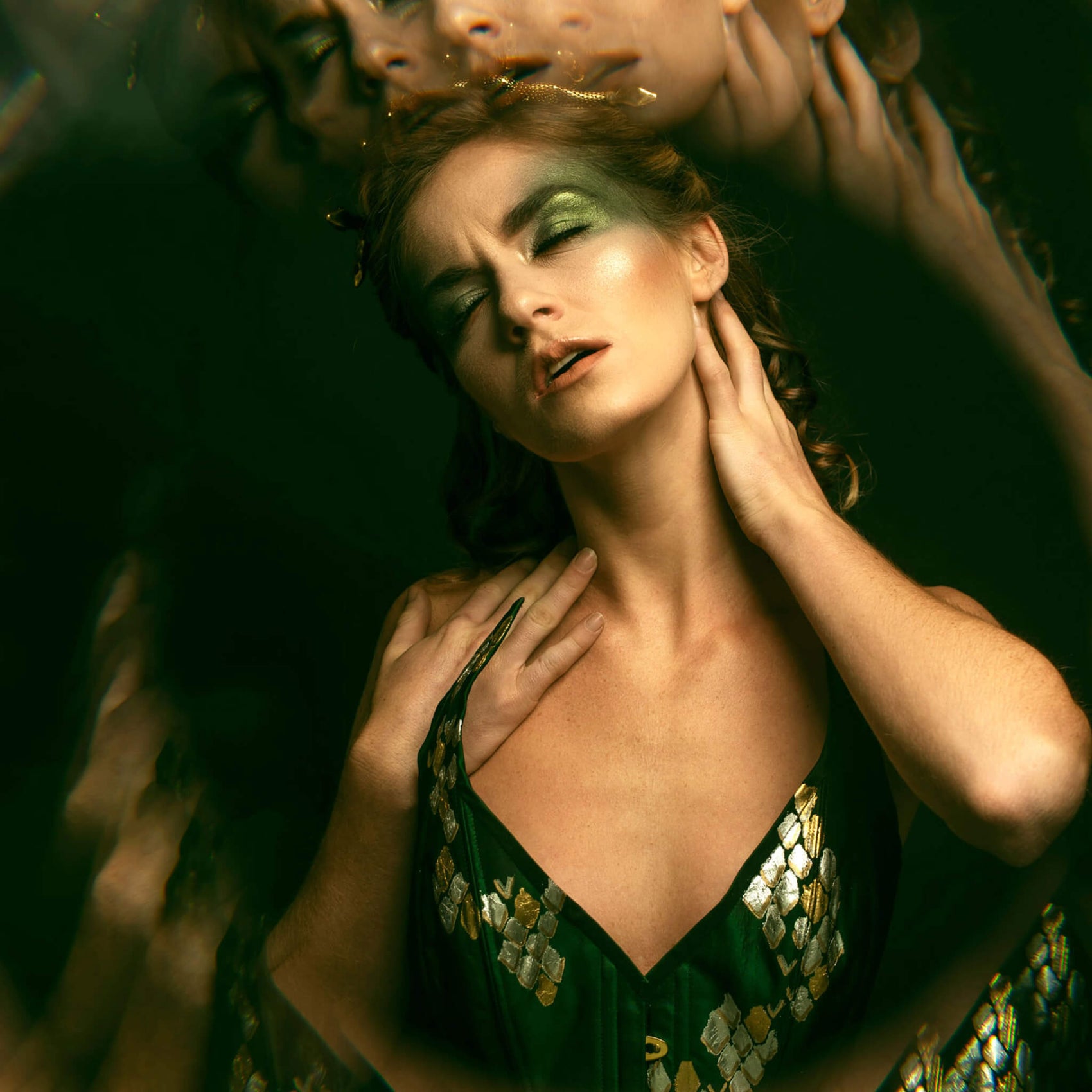 A The Bad Button bespoke corset design shows a woman in a green corset with gold detailing, refracting imagery of her face surrounding her as part of the rebranding case study.