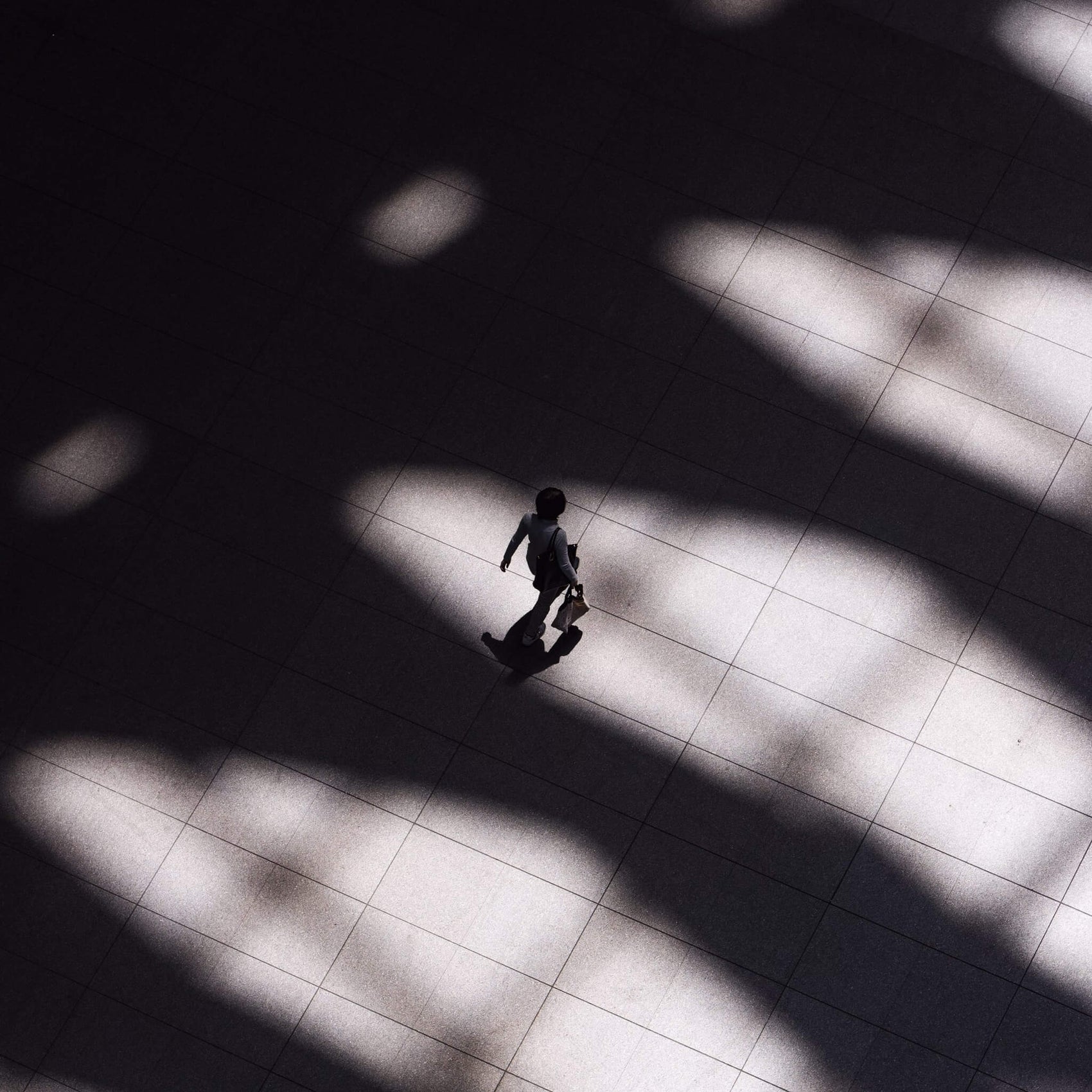 Copywriter Brand identity case study brand stock photography for Wordly showing a person walking through a spacious tiled room.