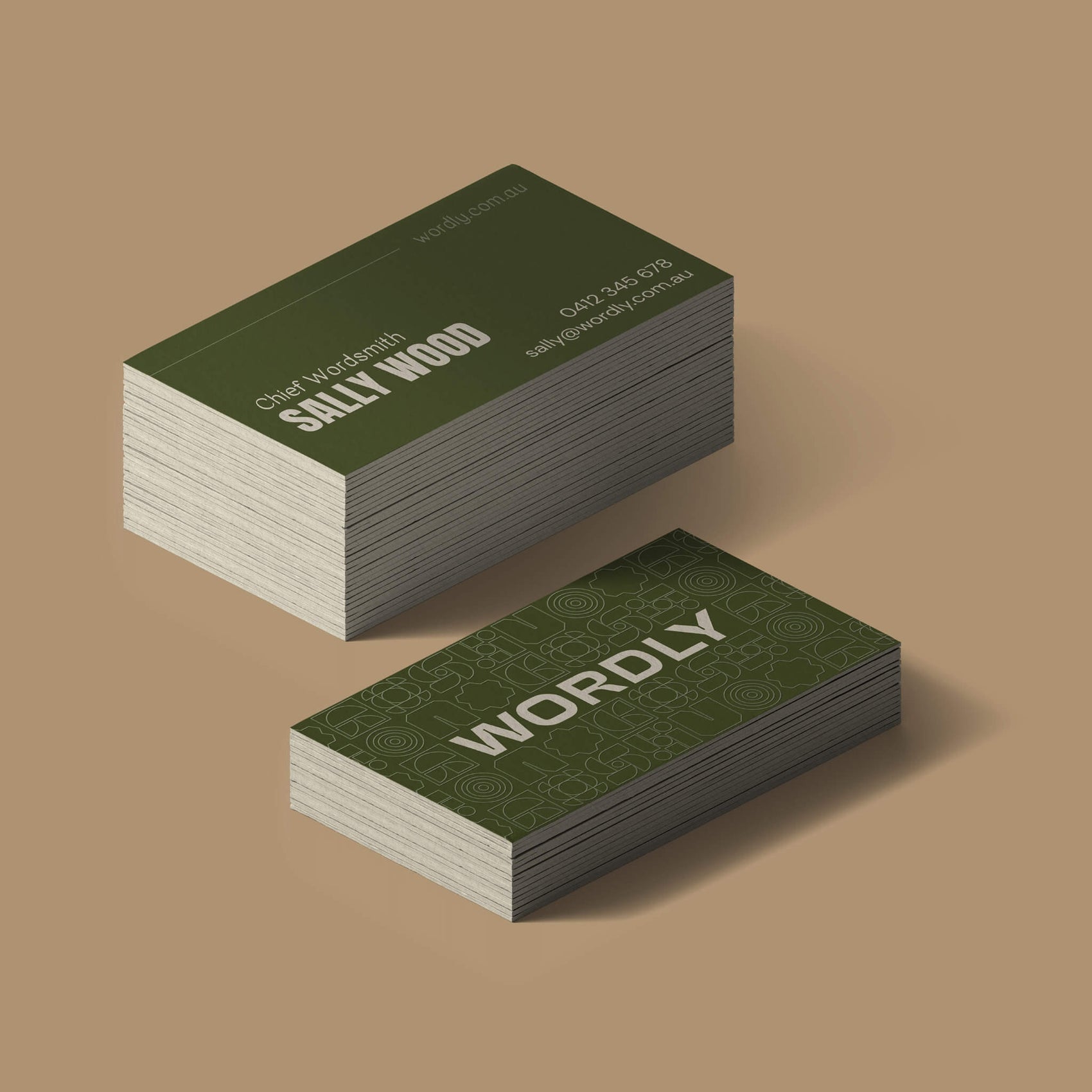 Copywriter Brand identity case study showing the Wordly business cards on a tan background. The front of the mid-toned green card features the brand icon in cream and spot UV varnish of the brand pattern while the back features founder Sally’s details.